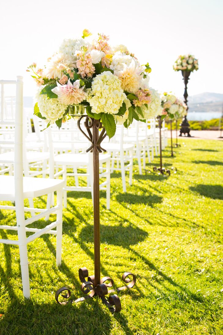 At the outdoor ceremony, aisles were lined with candelabras filled with pink and ivory hydrangeas, roses and dahlias.