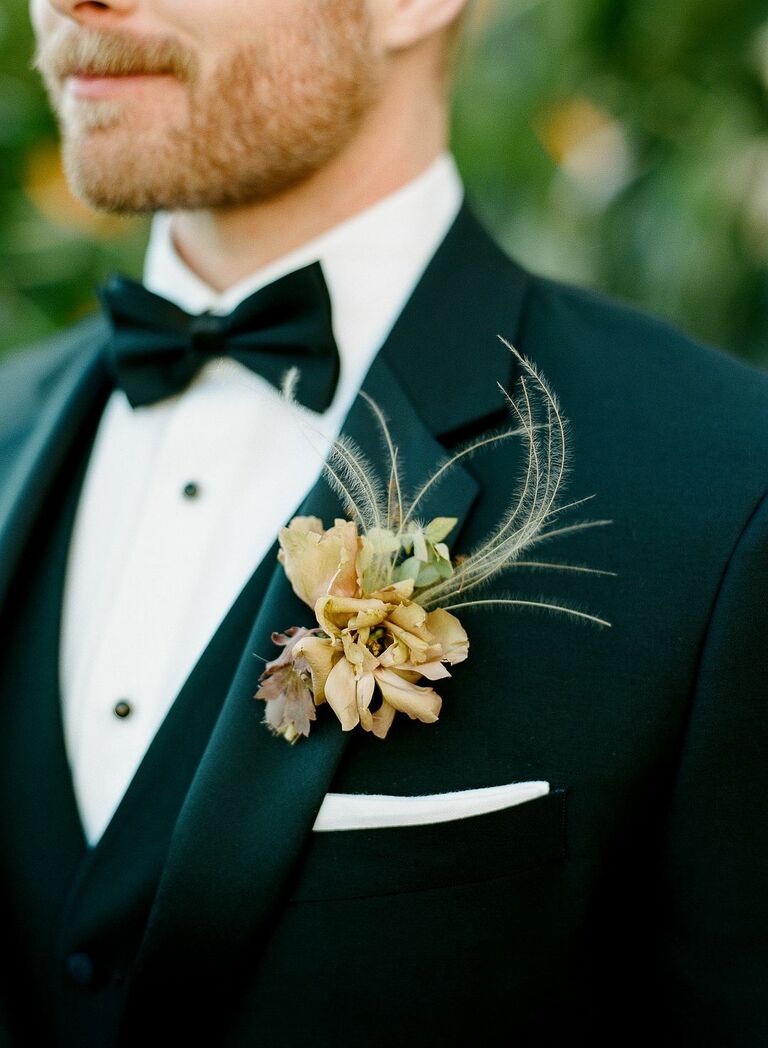 close-up of lapel on groom wearing black tuxedo with pale yellow boutonniere