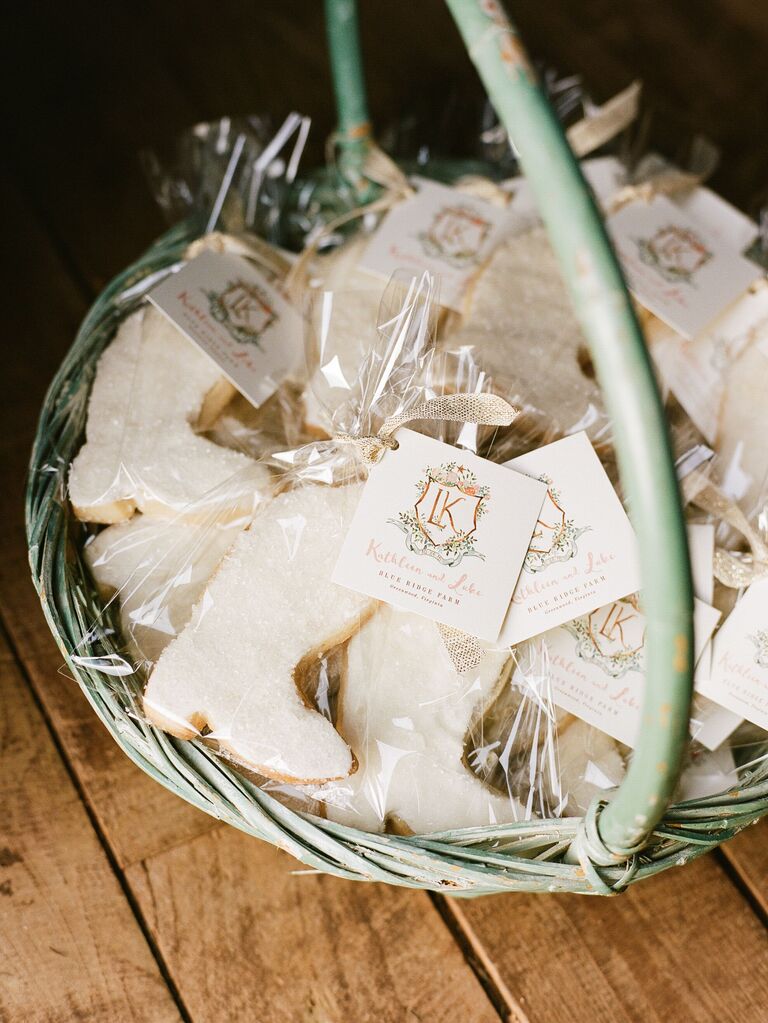 Cowboy-boot shaped cookies wrapped in cellophane sit in a pale green basket to be given to guests as party favors. 
