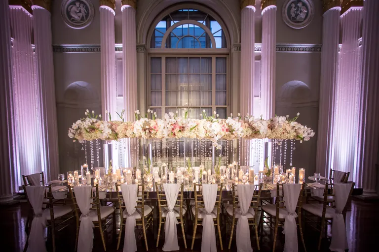 Main table at a wedding with lush floral centerpiece. 