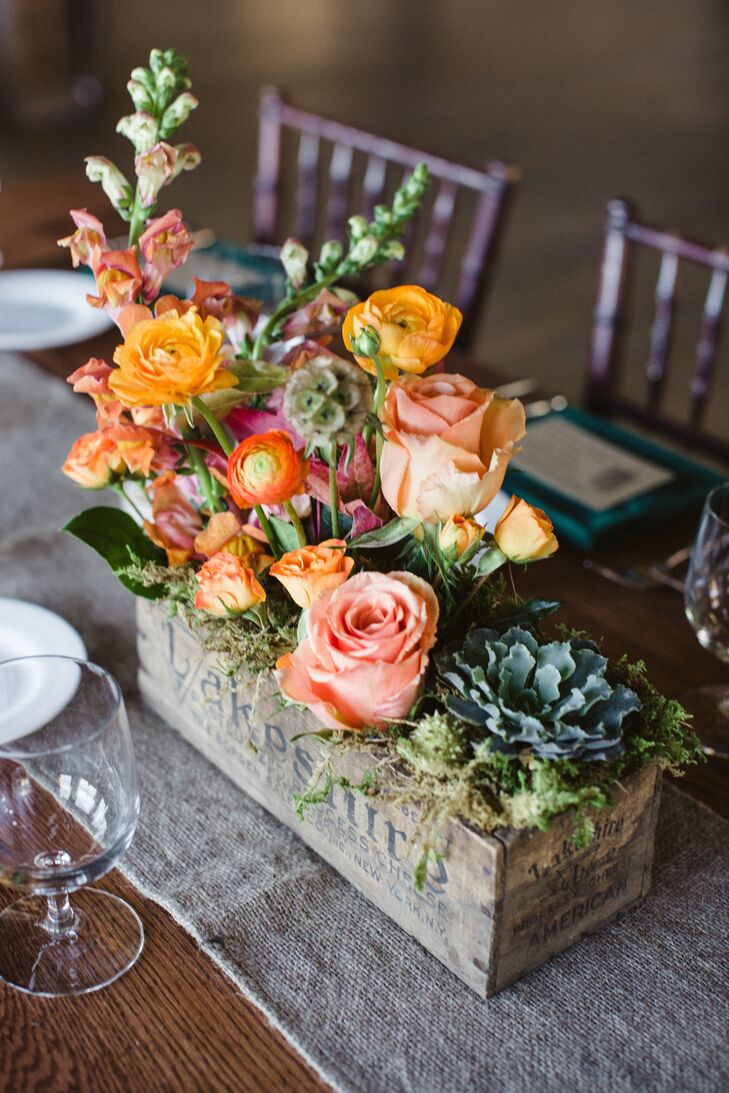 Centerpieces were made with a mix of succulents and orange and peach roses.  The antique wooden boxes were found by family and friends at local yard sales throughout the couple's engagement.