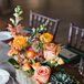 Centerpieces were made with a mix of succulents and orange and peach roses.  The antique wooden boxes were found by family and friends at local yard sales throughout the couple's engagement.