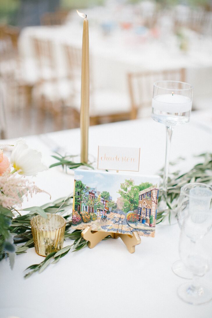 On the center of each table, Nina and Tristan placed a canvas painting of a city they had visited together. They were painted by their extremely talented friend Annie Sorge. On the back of each painting, she put the date of the trip, along with a small description of their favorite part. Another one of their friends, Cindy Carney, did all the calligraphy including the city names sitting on top of the canvas paintings.