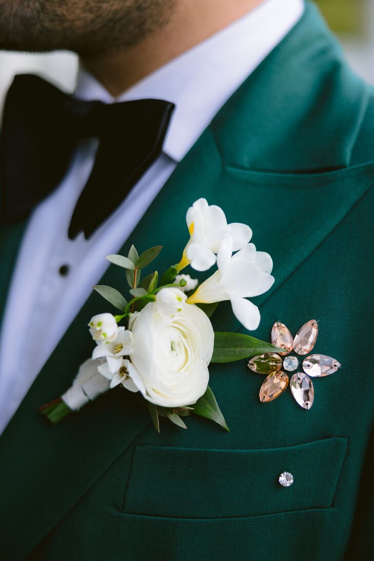 Delicate Boutonniere With Two Kinds of White Flowers and Greenery on Emerald Suit