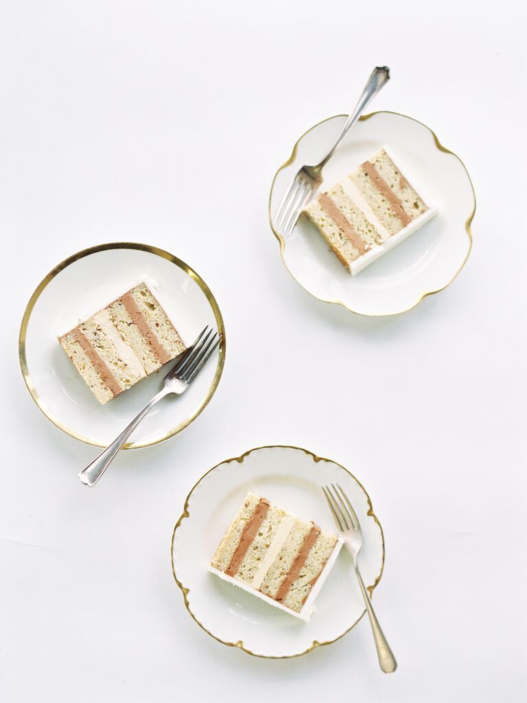 slices of wedding cake on gold rimmed porcelain plates
