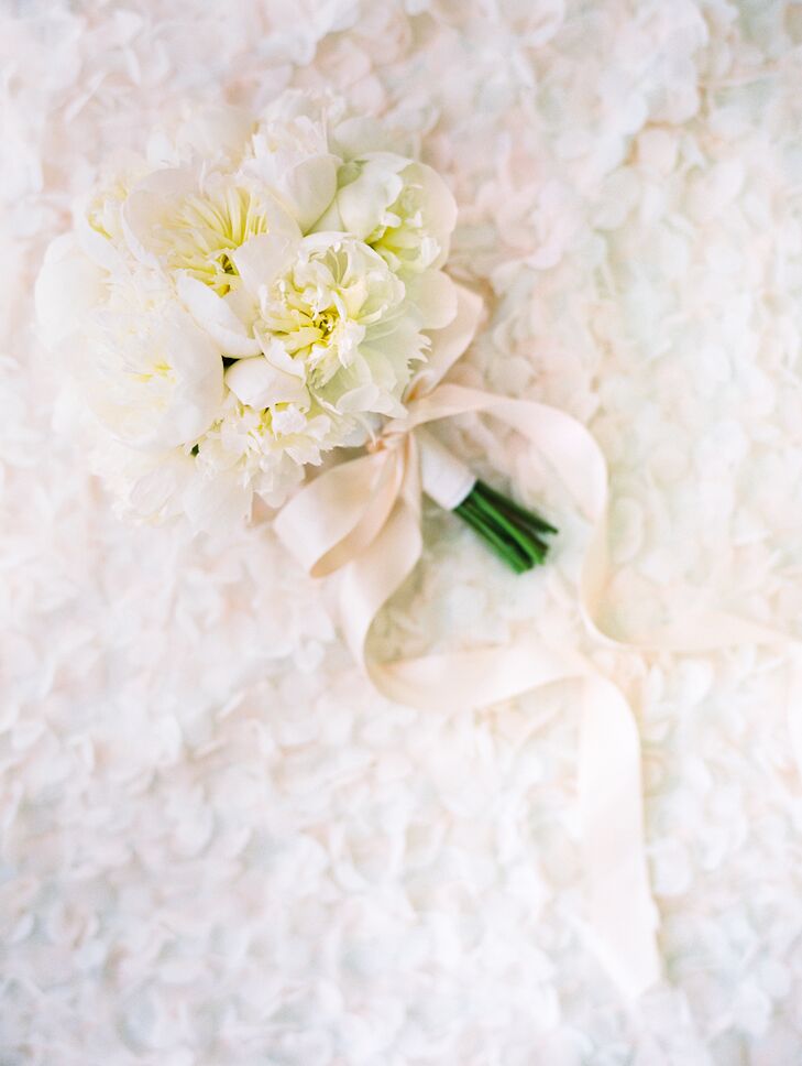 A tight, monochromatic bouquet of white peonies finished the bride's polished look.