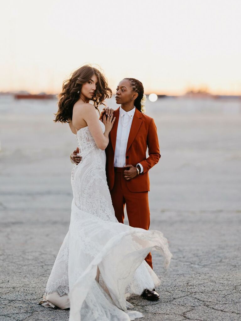 person wearing wedding dress with person wearing burnt orange hued suit