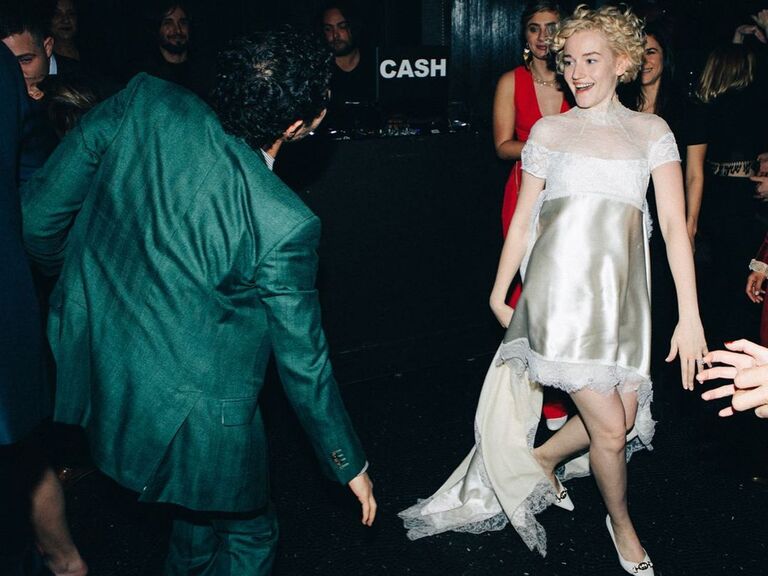 Julia Garner wears a soft silk white dress at her wedding reception. 