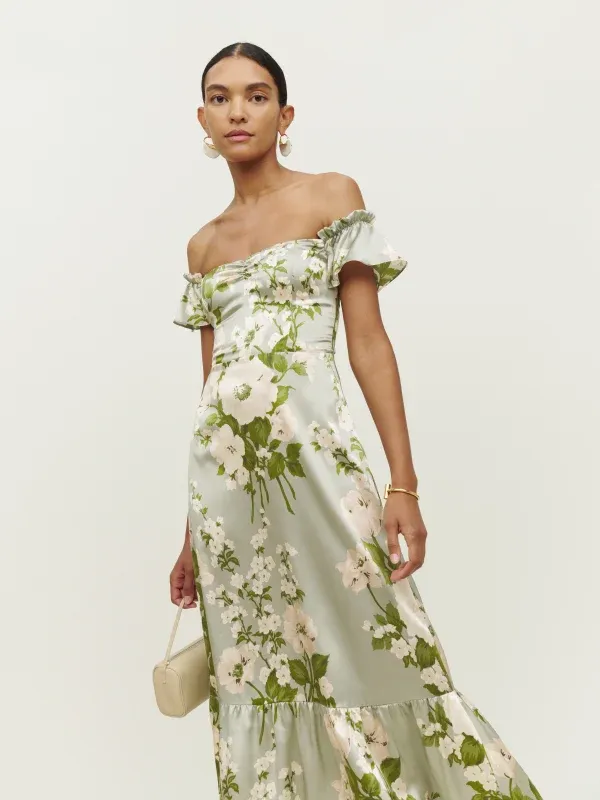 Model wears a pale green silk gown with a floral pattern. 