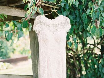 Simple lace wedding dress hanging outside