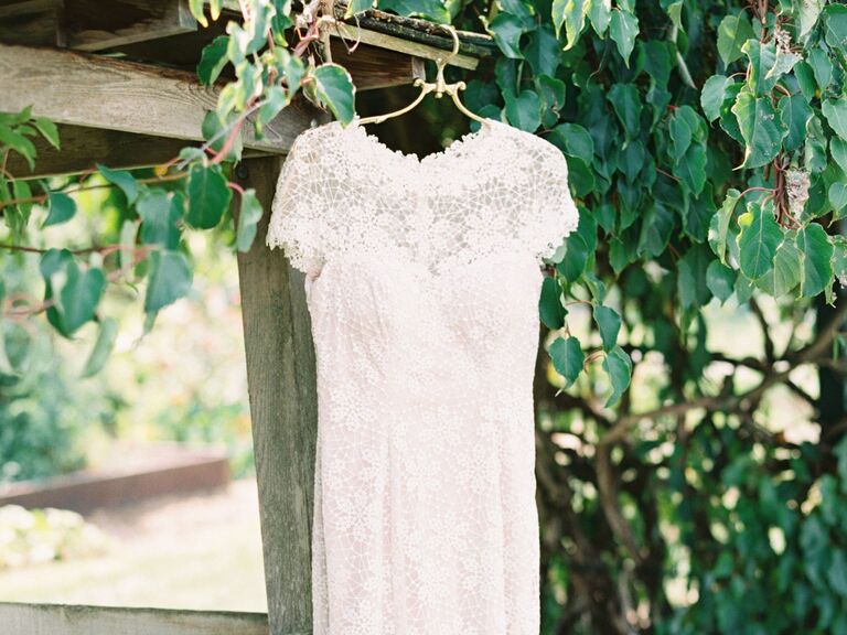 Simple lace wedding dress hanging outside