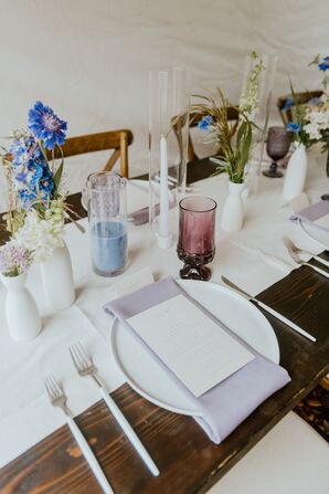 Rustic Table With White Runner, Lavender Napkins, Pastel Candles, Goblets and Colorful Wildflowers