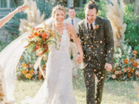 Bride and groom walking down the aisle through champagne sprays at The Greenhouse at Driftwood wedding venue in Dallas 
