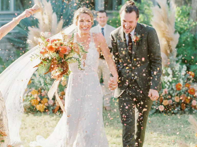 Bride and groom walking down the aisle through champagne sprays at The Greenhouse at Driftwood wedding venue in Dallas 
