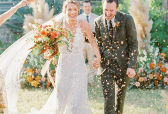 Bride and groom walking down the aisle through champagne sprays at The Greenhouse at Driftwood wedding venue in Dallas 