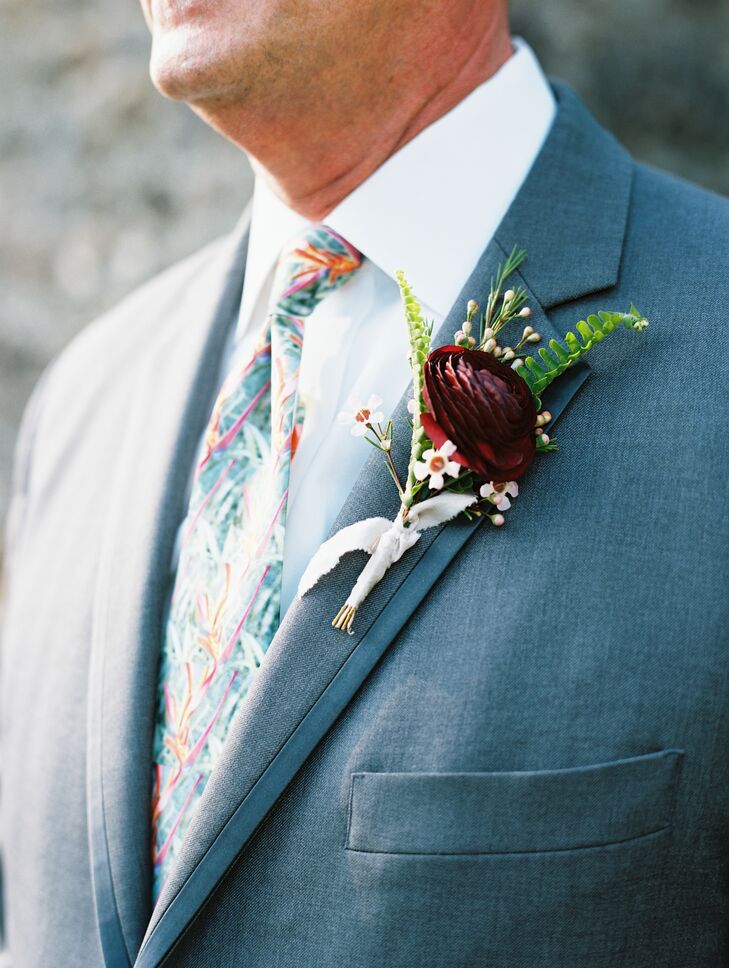 Boutonnieres were crafted with delicate fern sprigs and a single deep burgundy blossom.
