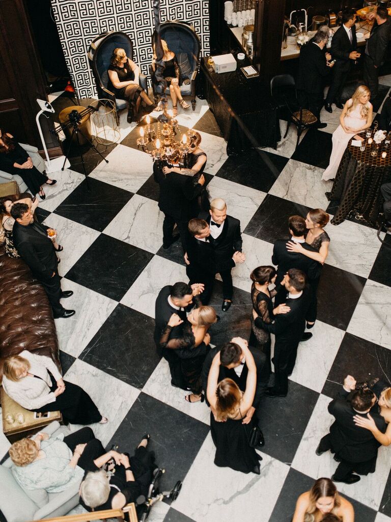 aerial view of wedding guests dancing on top of black and white checkerboard tile dance floor