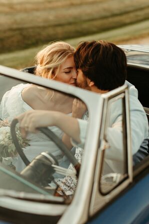 Bride and Groom Share a Kiss Inside Vintage Car