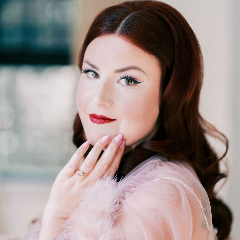 Bride wears her hair in classic waves with a middle part. 