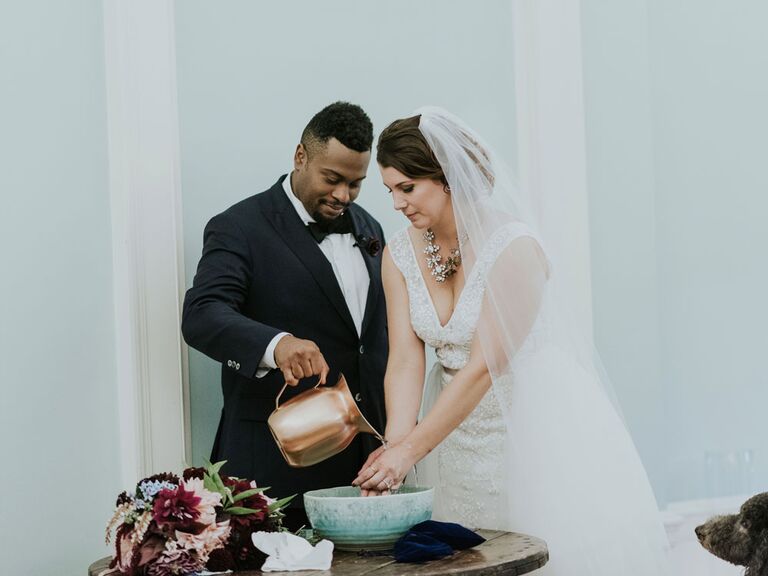 Bride and groom pouring water during hand-washing unity ceremony