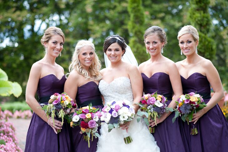 The bridesmaids wore Jim Hjlem A-line ballgowns with a sweetheart neckline in eggplant.The bride chose to have a bouquet of whites, creams and various shades of purple, while selecting jewel tones for her bridesmaids.