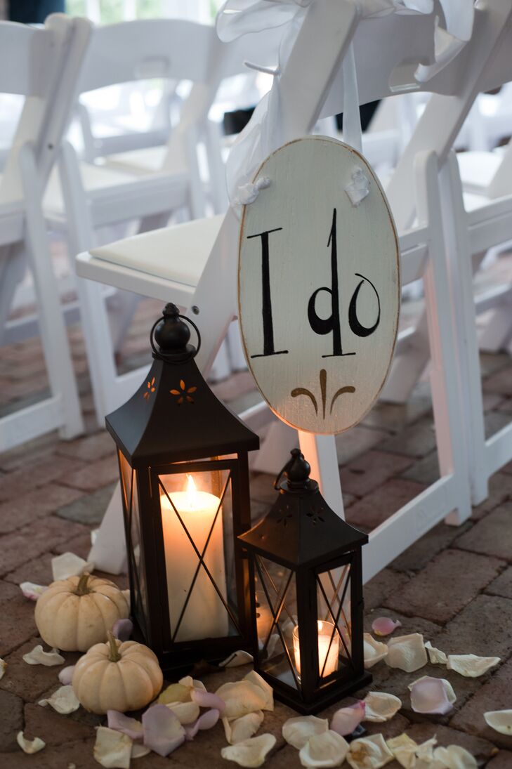 The Ashford Estate boasts a large brick floored barn that served as the ceremony site. Small candlelit lanterns accompanied by strewn flower petrels and pastel gourds lined the aisle.