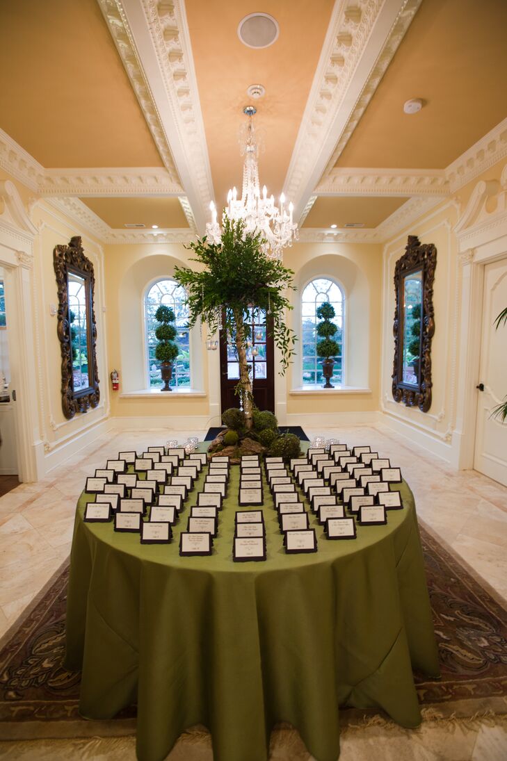Eggplant and sparkle accents decorated the classically set place card table. The green table cloth and surrounding plants created a simple, elegant setting that blended beautifully with the venue decor.