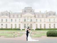 Couple embracing outside beautiful château-like venue