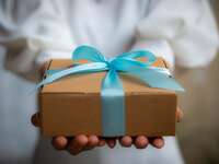 Wedding guest holding gift wrapped in blue bow