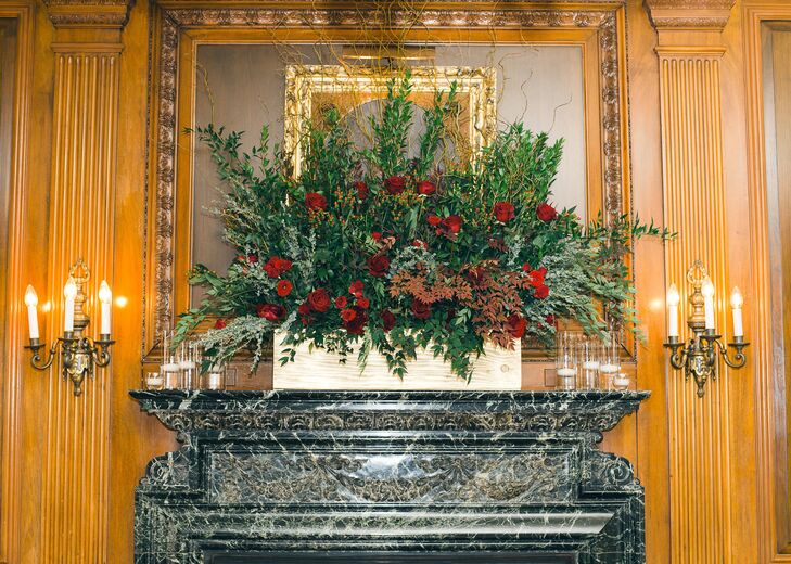 Ellie and Adam kept the decor simple for the ceremony, allowing the character of the historic property to take center stage. A single floral arrangement, filled with lush greenery, eucalyptus, willow branches and dark red roses was placed on the mantlepiece.