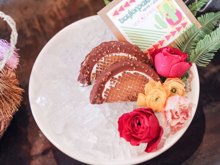 Bowl of ice holds two chocolate ice cream dessert tacos. 