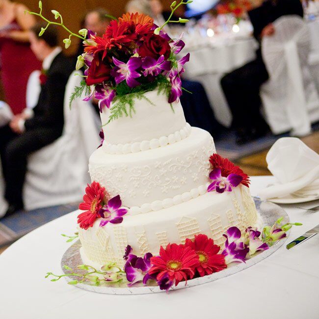 Talk about glam! Rich red flowers cascaded down the three-tiered cake iced decorated with a custom-monogram.