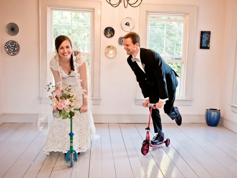 Bride and groom riding kids' scooters. 