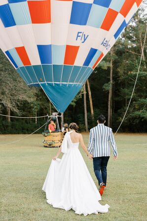 Groom in Seersucker Suit, Bride With Train Walking Toward Hot Air Balloon