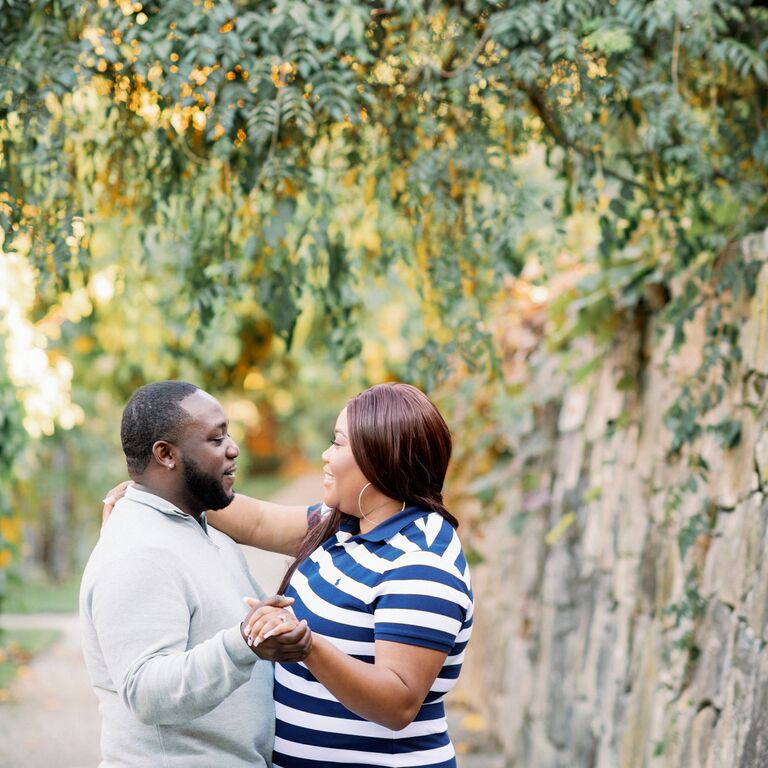 Couple embraces under vines during engagement photo shoot