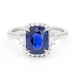 A sapphire engagement ring, the blue stone encircled by small diamonds.