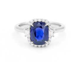 A sapphire engagement ring, the blue stone encircled by small diamonds.