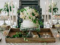 one tier wedding cake with ivory and blush flowers displayed atop glass cake stand