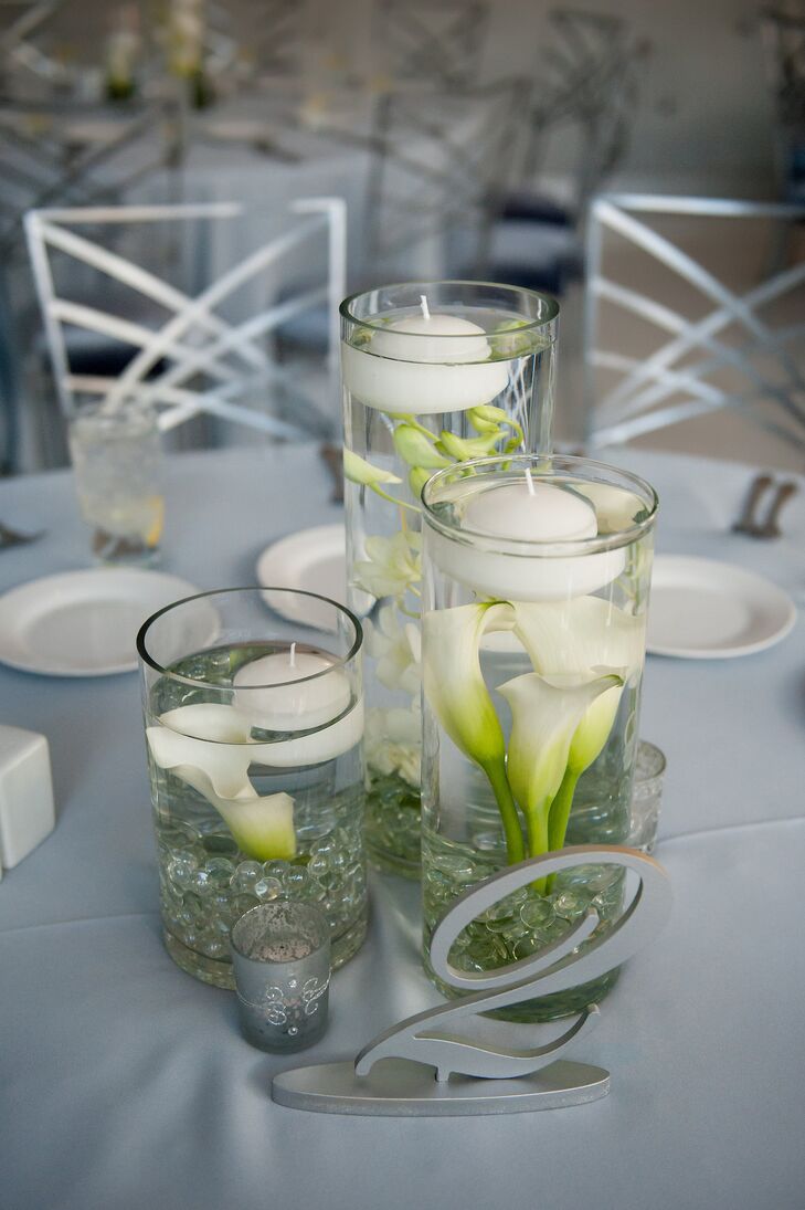 The dining tables the Clayton on the Park in Scottsdale, Arizona, hosted modern minimalist submerged bud vases of white callas, roses and hydrangeas topped with floating candles and elegant silver table numbers.