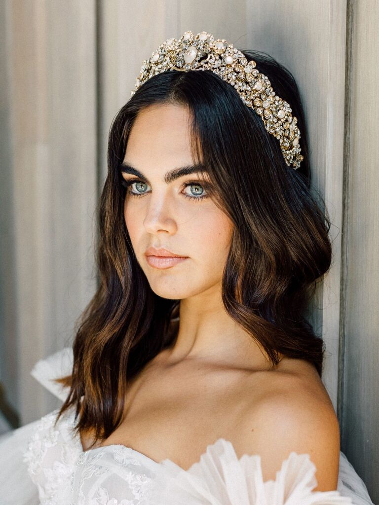 Model wears a sparkling crown with floral embellishments. 
