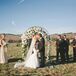 Lydia and Brandon shared their first kiss in front of the wedding arch draped with an overflowing arrangement of white peonies mixed with greens—a romantic decoration for a romantic occasion.