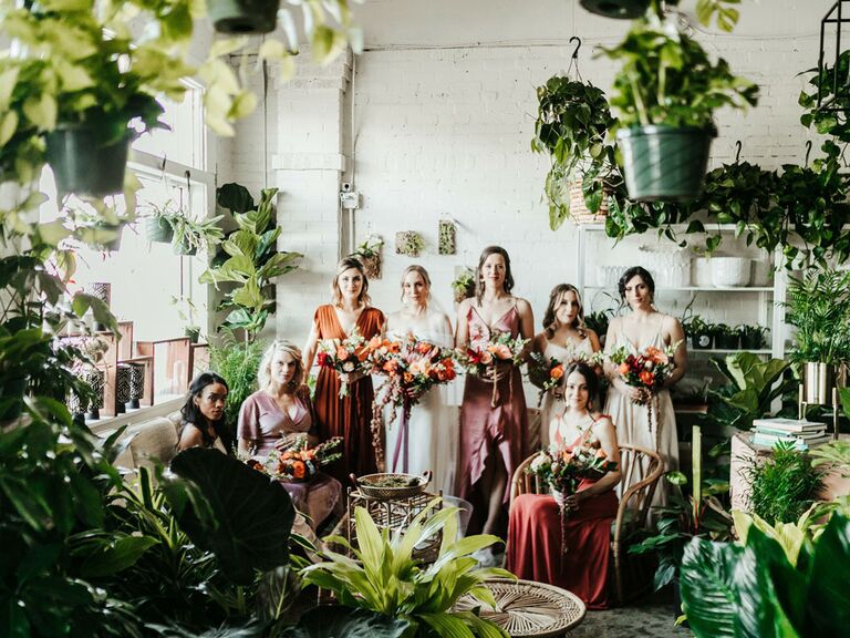 Mismatched bridesmaids dresses in shades of pink, orange and burgundy