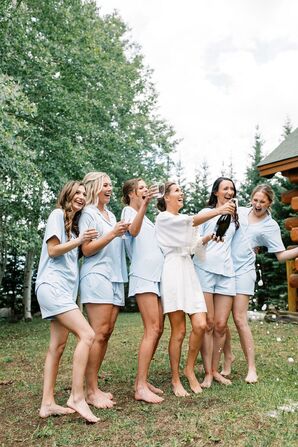 Bridesmaids in Blue Pajamas Popping Champagne While Getting Ready