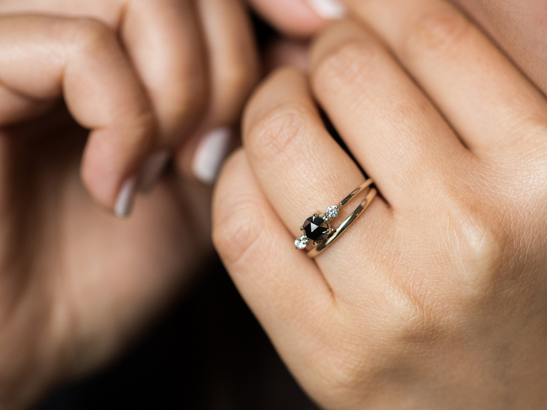A gorgeous black diamond, flanked by two white diamonds, on a delicate engagement ring.