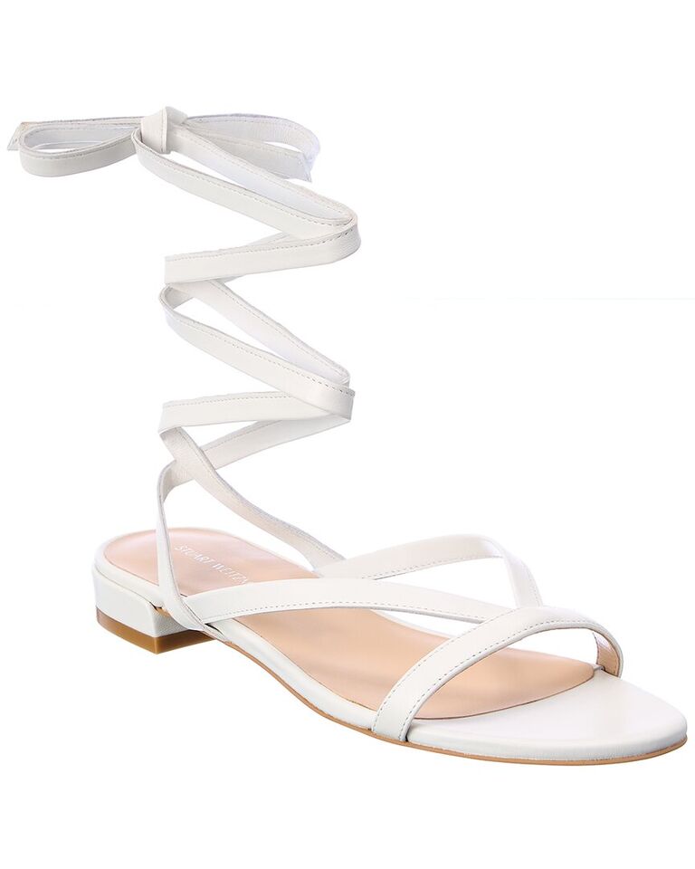 White flat shoes with crossing straps. 