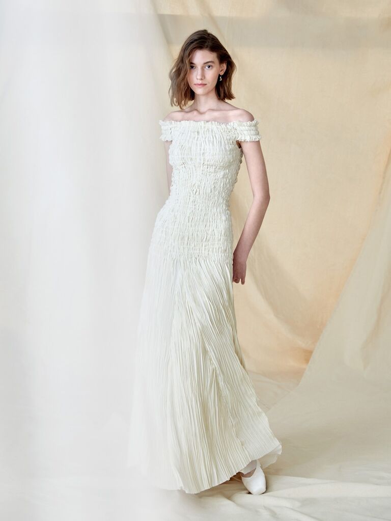 Model wears an off the shoulder white dress by Cortana. 