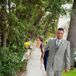 Adam wore a light gray three-piece suit paired with a striped gray and white tie that matched his overall look. He had vintage-inspired camera cuff links on his jacket, which added a personal touch to his attire.