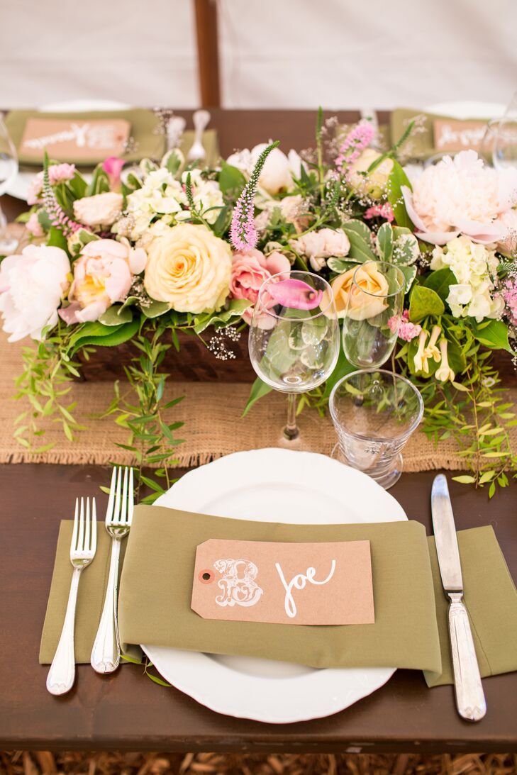 The reception tables combined both romantic and rustic touches. Each table was lined with a burlap table runner, covered with lush arrangements of peach and pink blooms including roses, peonies, astilbe and calla lilies. Pinky-peach place cards added a pop of color to the earthy brown linens.