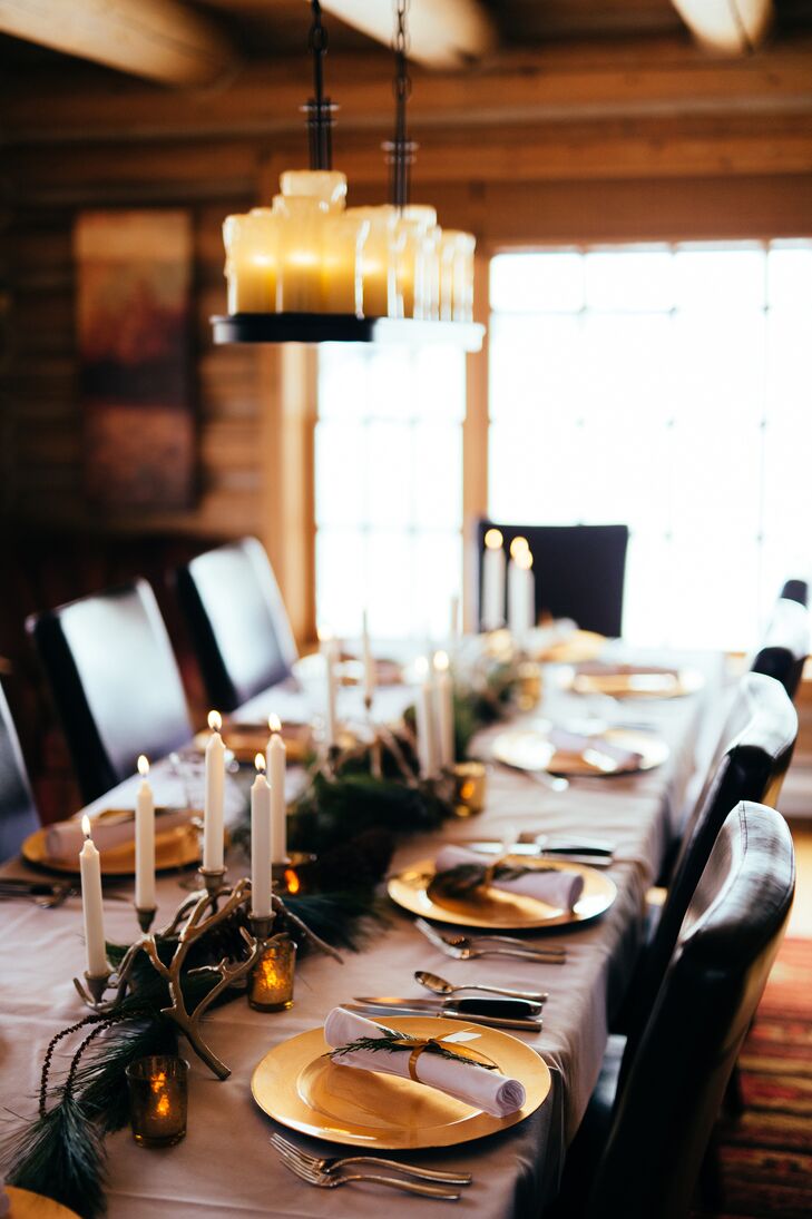 The reception tables were topped with white taper candles as well as tealight candles in gold mercury glass votives. The table was lined with an evergreen garland and small antlers for a rustic feel that fit the winter season.
