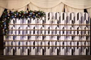 An Art Deco Themed Champagne Wall With Flowers and Traditional Jewish Toast "L'Chaim"